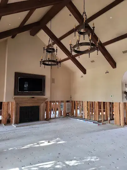 Vaulted great room with the lower drywall cut away and the flooring removed to bare slab during drying in Prosper, TX