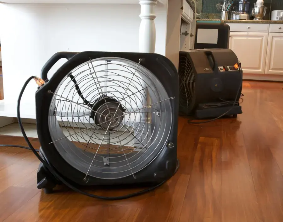 An axial fan and a dehumidifier running on a hardwood kitchen floor during water damage drying in an Allen home