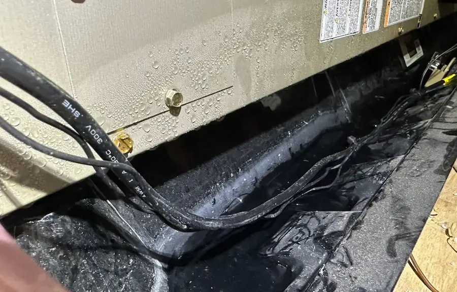 Attic air handler drain pan full of condensate water in a Prosper home