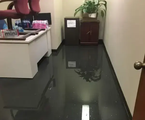Standing water across the floor of an office reception area during commercial water damage in Prosper, TX